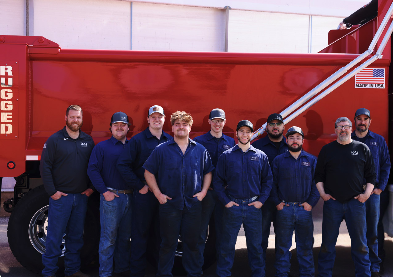 The Rugged team standing in front of a red dump body