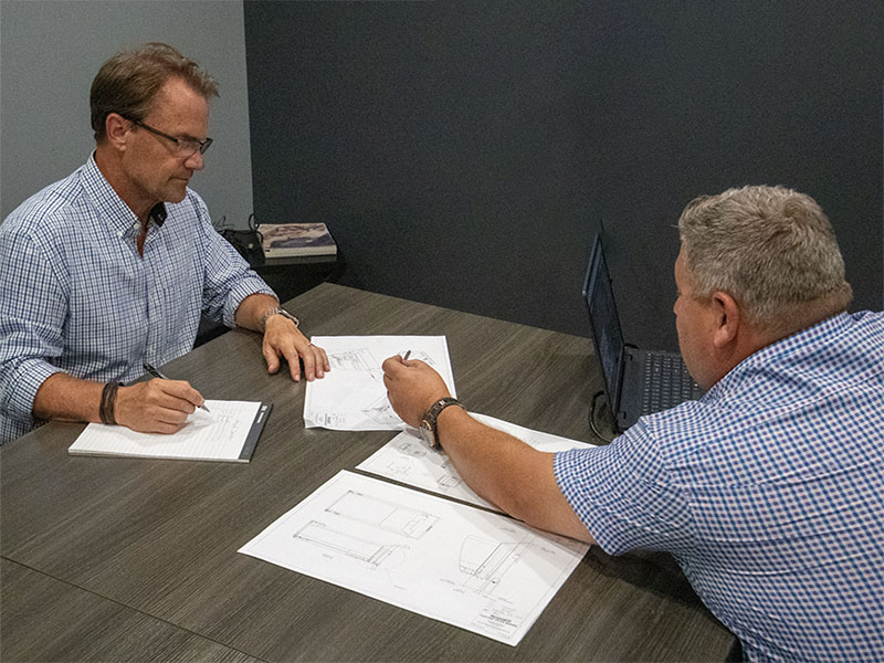 R&M fabricators reviewing build plans for a custom truck body